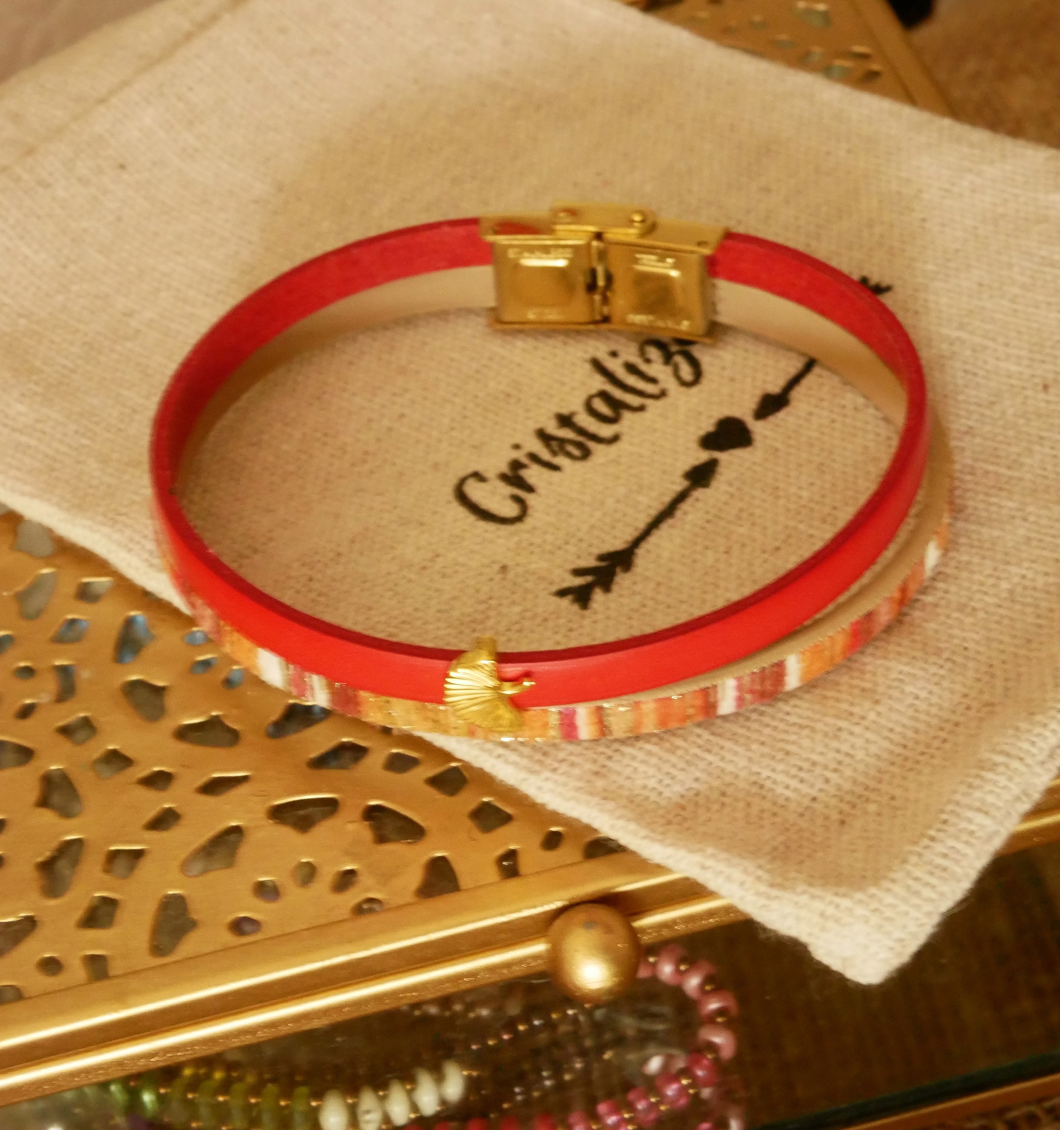 Bracelet duo cuir rouge et doré avec motif ginkgo.