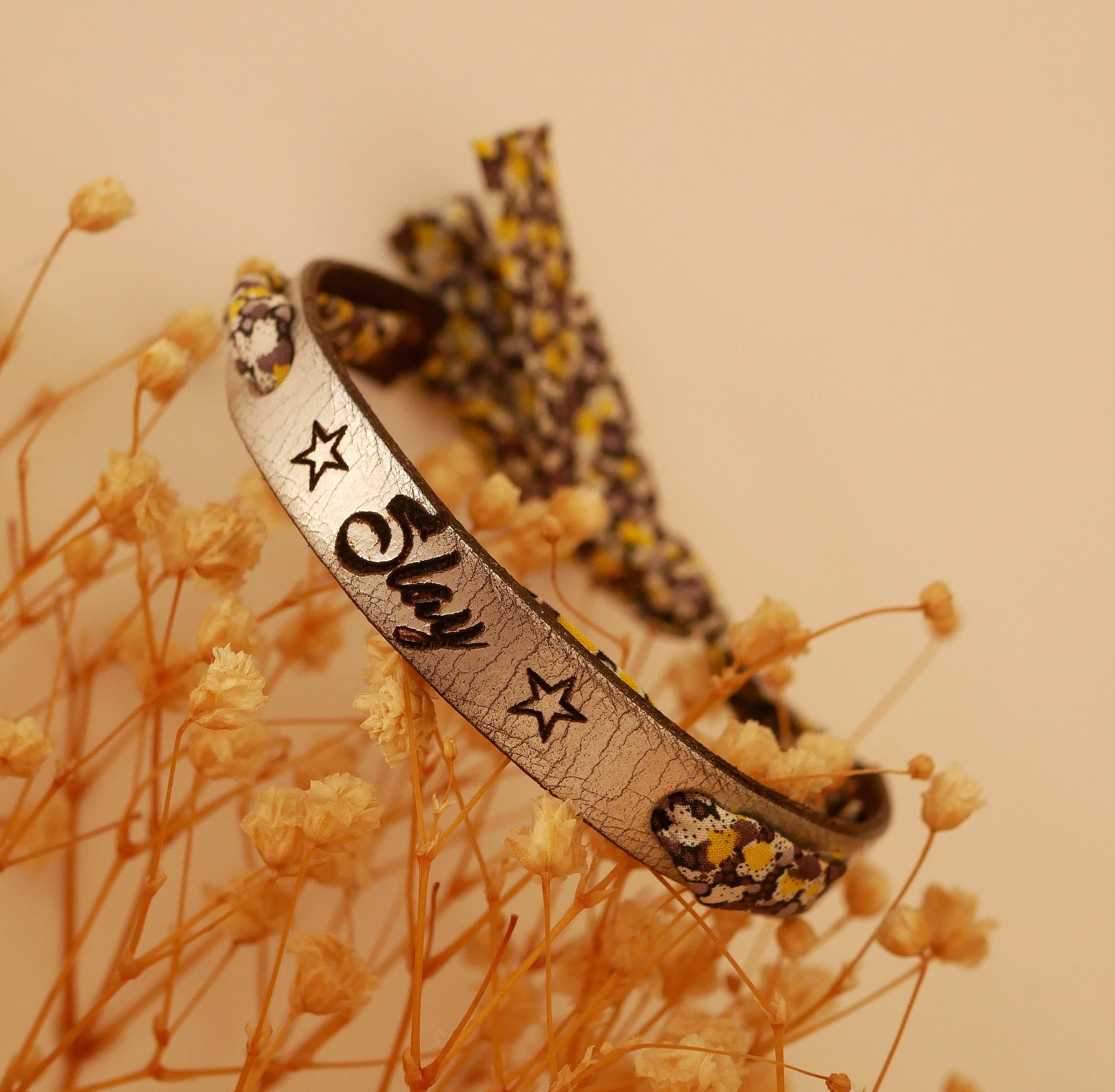 Bracelet personnalisé en cuir argenté avec étoiles et fleurs.