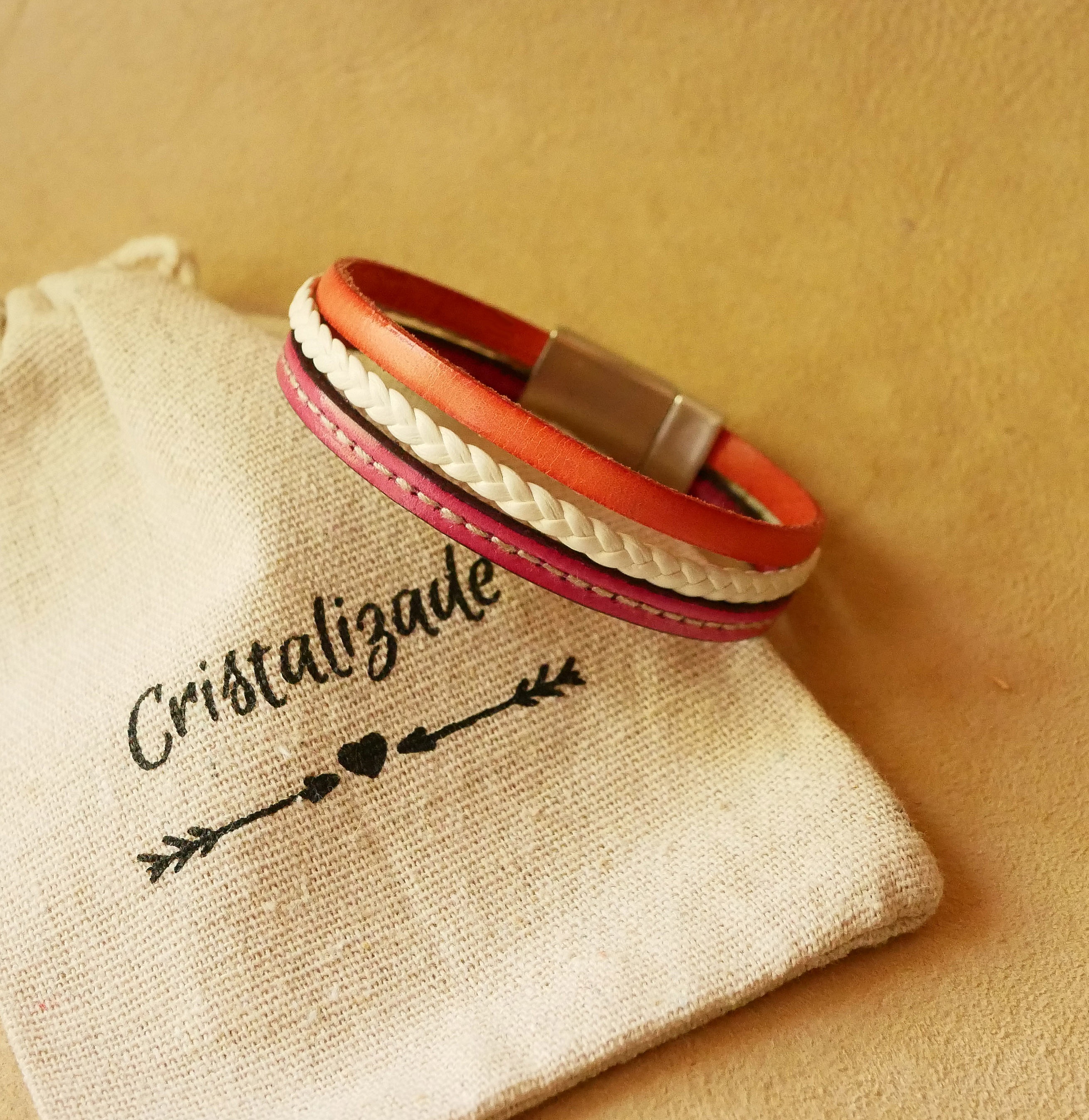 Manschettenarmband aus mehreren geflochtenen Ledern mit Steppn&auml;hten in Wei&szlig; und Koralle