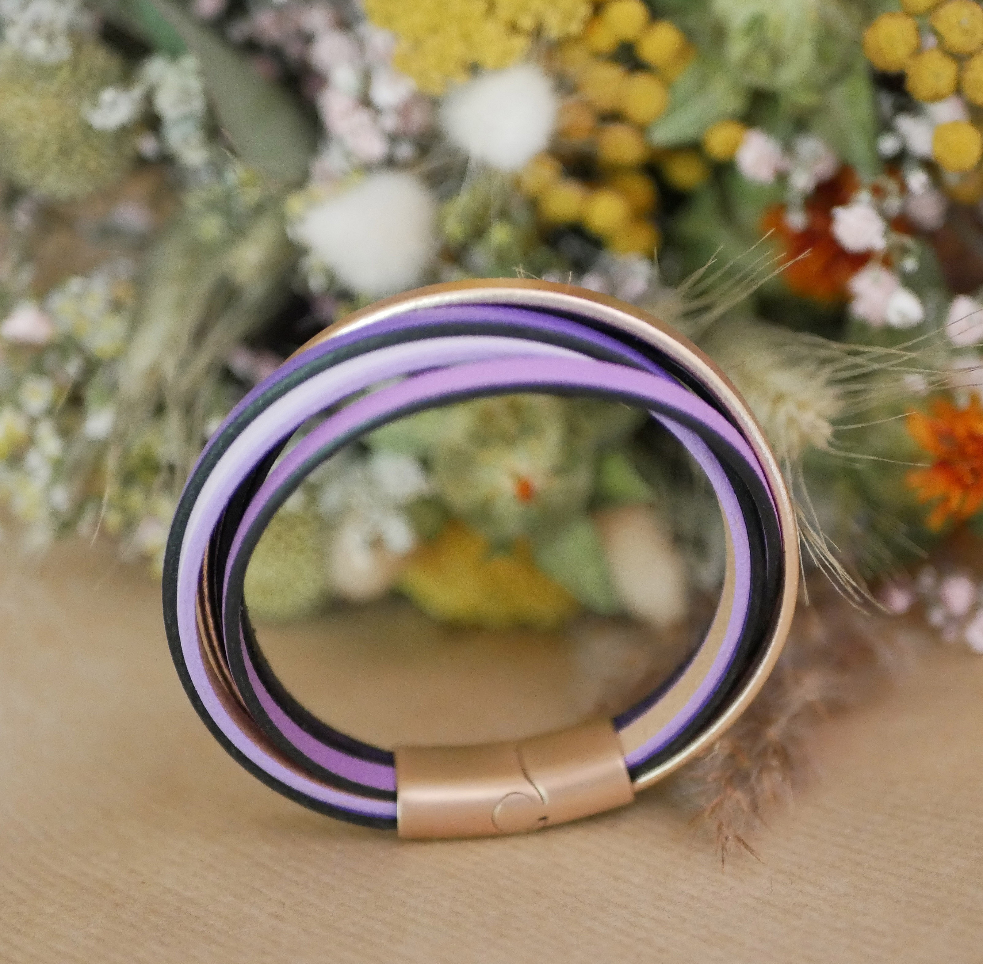 Bracelet manchette multi-cuirs violet et or rose avec fermoir.