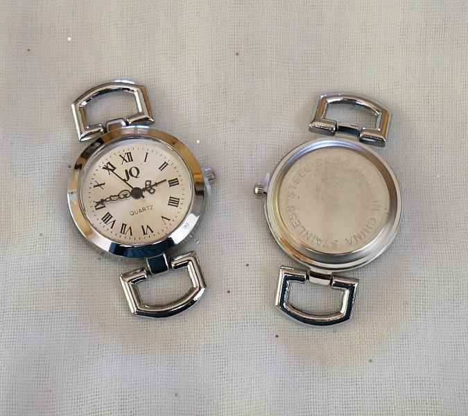 Cadran de montre argenté avec chiffres romains et dos acier.