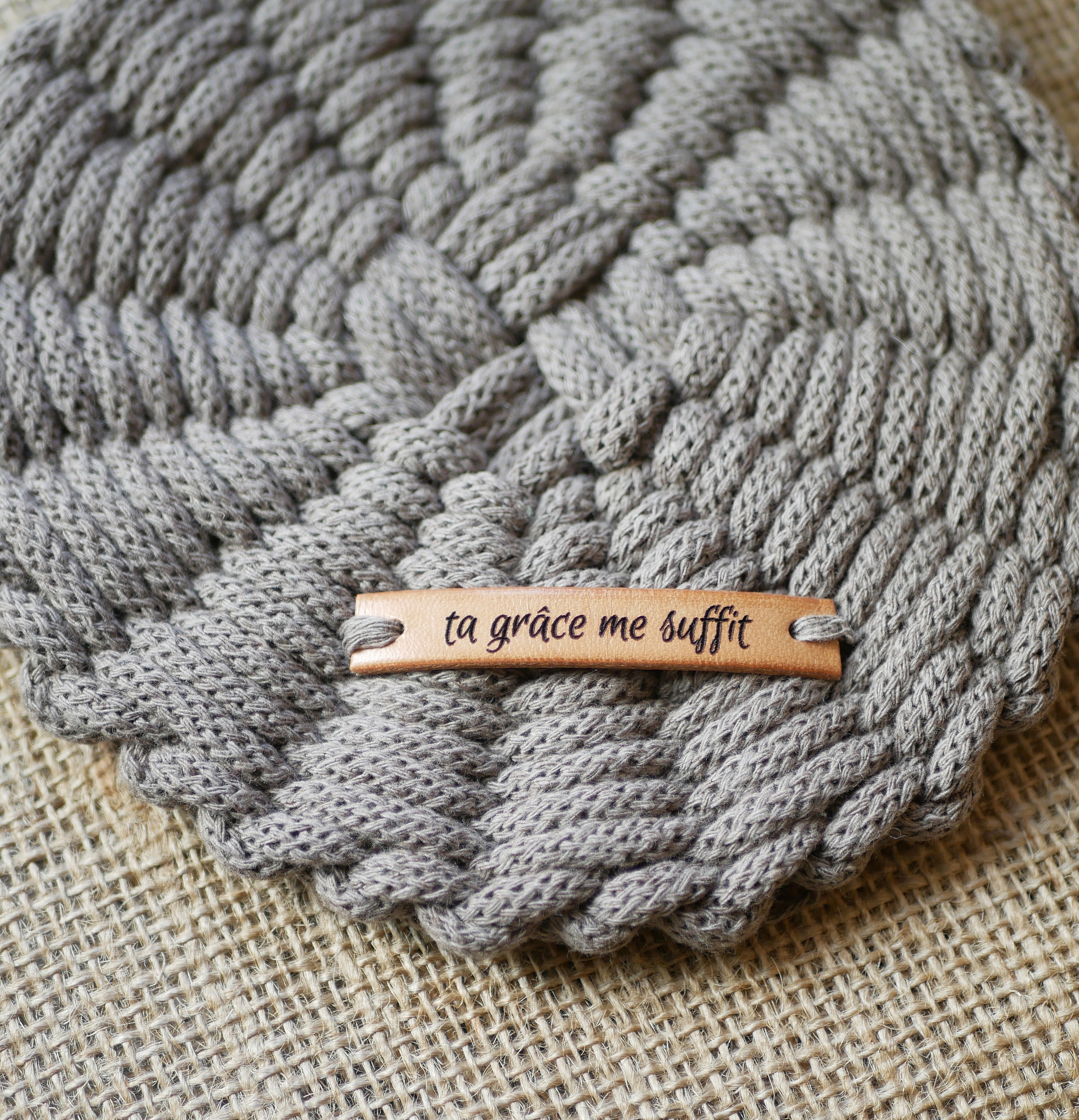 Sous-verre en macramé gris avec étiquette personnalisée gravée.