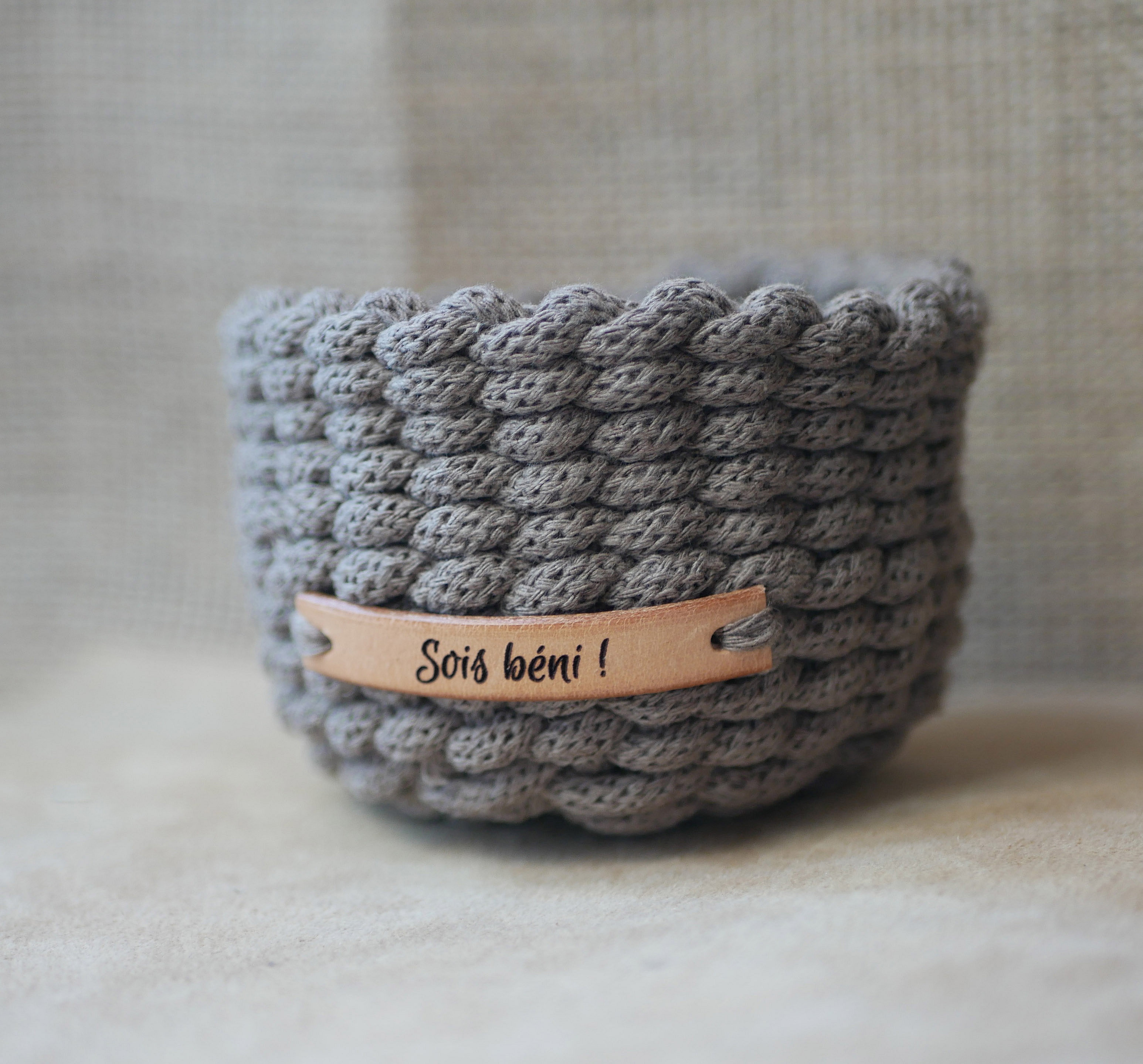 Petit panier en crochet gris personnalisable avec étiquette cuir.