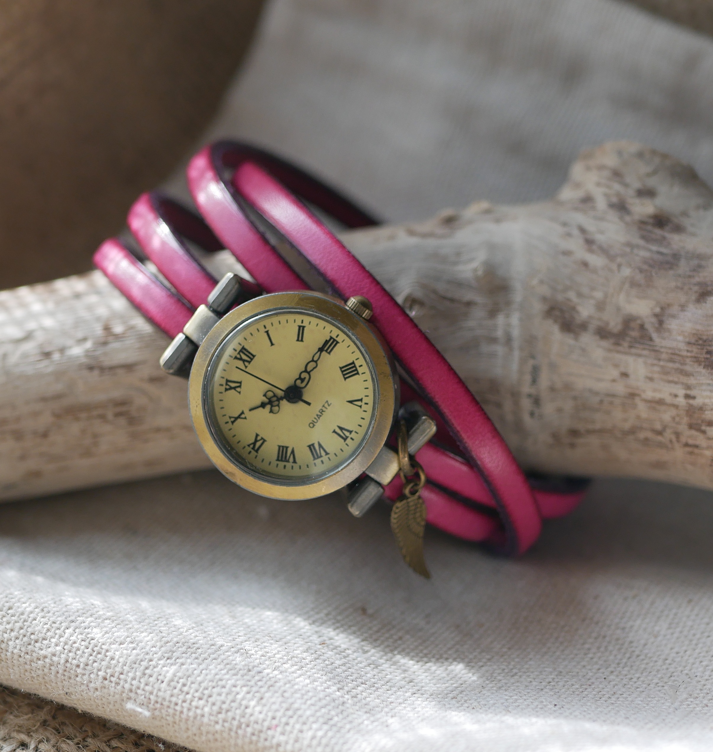 Montre bracelet en cuir rose personnalisable avec breloque aile.